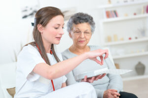 Nurse discussing medication with elderly woman